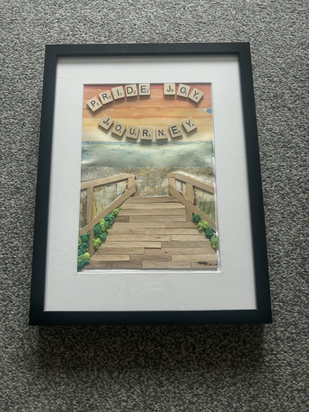 A framed painting of a path leading towards the light